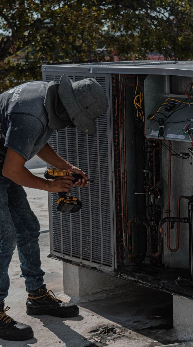 Technician servicing a rooftop air-conditioning unit