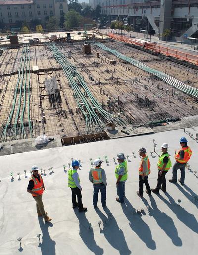 Site crew standing in a line on a concrete slab, casting long shadows